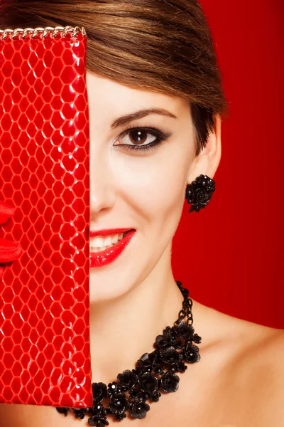 Beautiful girl with a red clutch bag — Stock Photo, Image