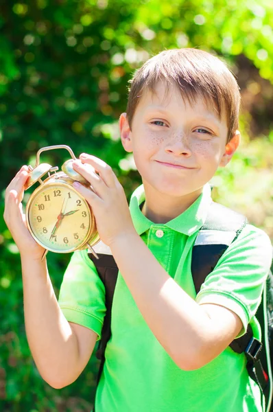 Junge mit Rucksack und Uhr in der Hand — Stockfoto