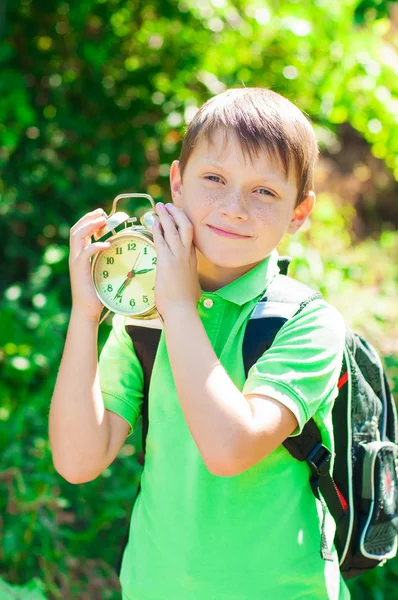 Junge mit Rucksack und Uhr in der Hand — Stockfoto