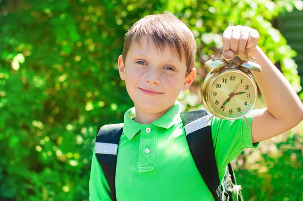 Boy with a backpack and a clock in hands — Stock Photo, Image