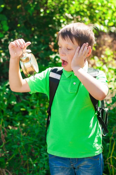 Ragazzo con uno zaino e un orologio in mano — Foto Stock