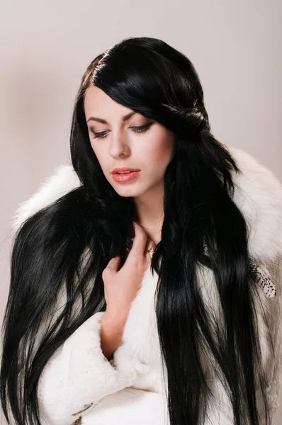 Hermosa chica en un abrigo de piel blanca — Foto de Stock