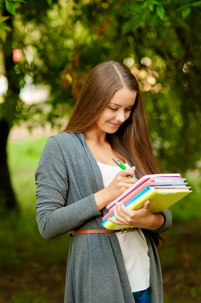 Tiener meisje met boeken in handen — Stockfoto