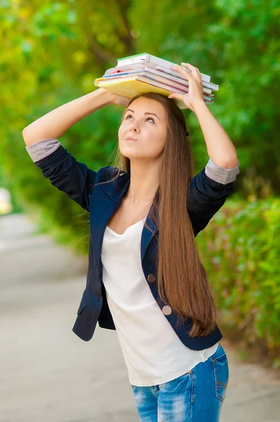 Tiener student meisje houdt van boeken over haar hoofd — Stockfoto