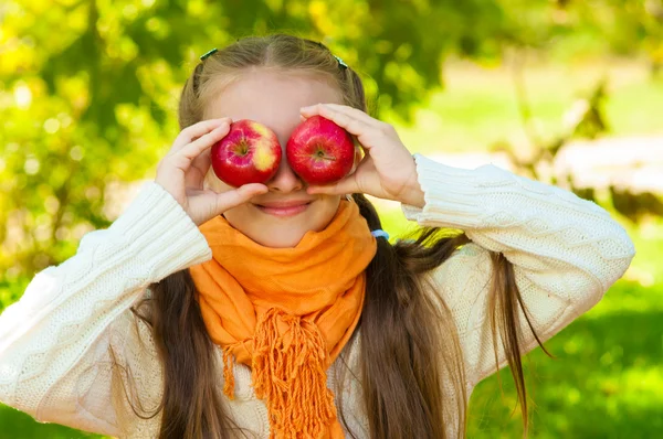 Petite fille avec des pommes dans le parc — Photo