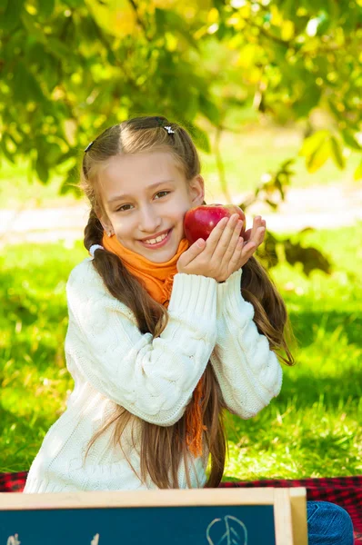 Petite fille avec des pommes dans le parc — Photo