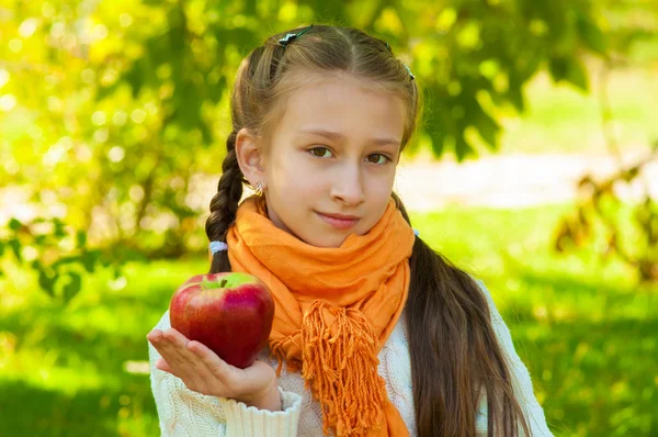 Petite fille avec des pommes dans le parc — Photo