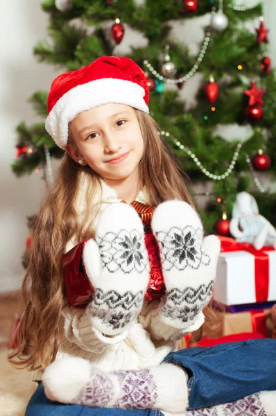 Liten flicka med långt hår nära julgran — Stockfoto