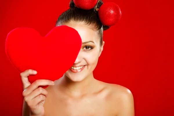 Ein junges Mädchen mit einem roten Herzspielzeug — Stockfoto