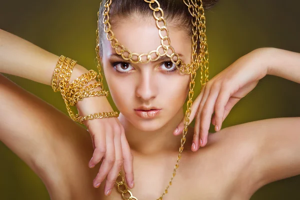 Flicka med gyllene make-up och dekoration av guld — Stockfoto