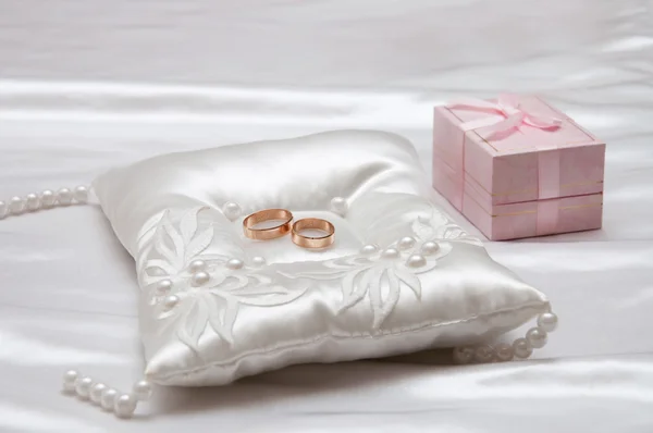 Los anillos de boda en una almohada blanca —  Fotos de Stock