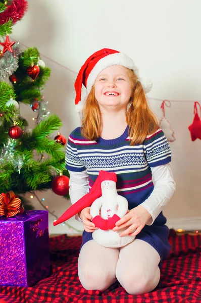 Petite fille près du sapin de Noël avec des cadeaux — Photo