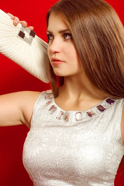 Belle fille aux cheveux longs dans une robe et un embrayage à la mode — Photo