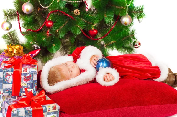 Bebê em Santa fantasia dormindo na árvore de Natal — Fotografia de Stock
