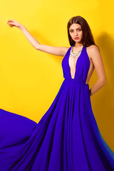 Vacker ung flicka med långt hår i en blå klänning — Stockfoto
