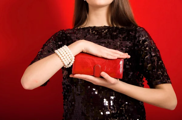 Beautiful girl with a red clutch bag — Stock Photo, Image