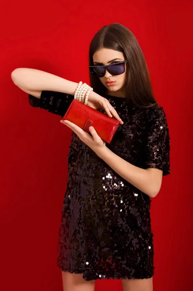 Beautiful young girl with long hair in a  black small  dress — Stock Photo, Image