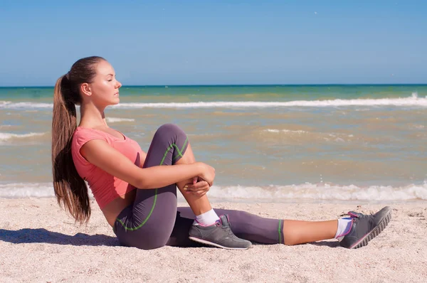 Jeune belle fille athlète faisant du sport sur la plage — Photo