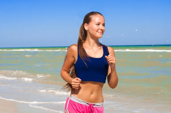 Young beautiful girl athlete  on the beach — Stock Photo, Image