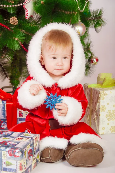 Baby in Santa costume at the Christmas tree with gifts — Stock Photo, Image