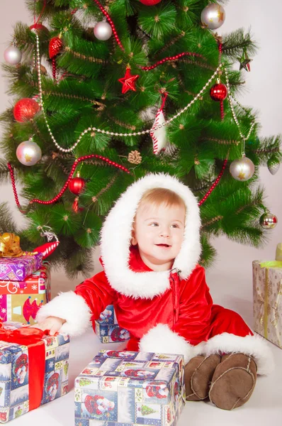 Bebê em Santa traje na árvore de Natal com presentes — Fotografia de Stock