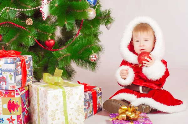 Baby i Santa dräkt på julgranen — Stockfoto