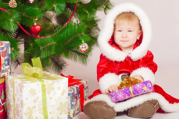 Bebê em traje de Santa na árvore de Natal — Fotografia de Stock