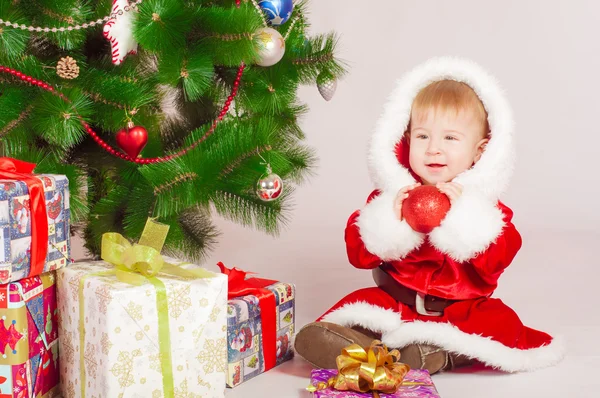 Baby in Santa costume at the Christmas tree — Stock Photo, Image