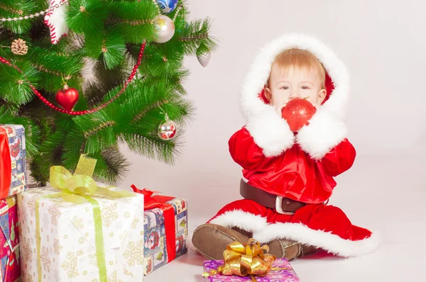 Baby in Santa costume at the Christmas tree — Stock Photo, Image