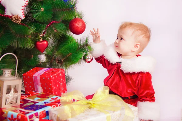 Bebê em traje de Santa na árvore de Natal — Fotografia de Stock