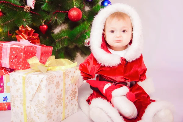 Bebê em traje de Santa na árvore de Natal — Fotografia de Stock