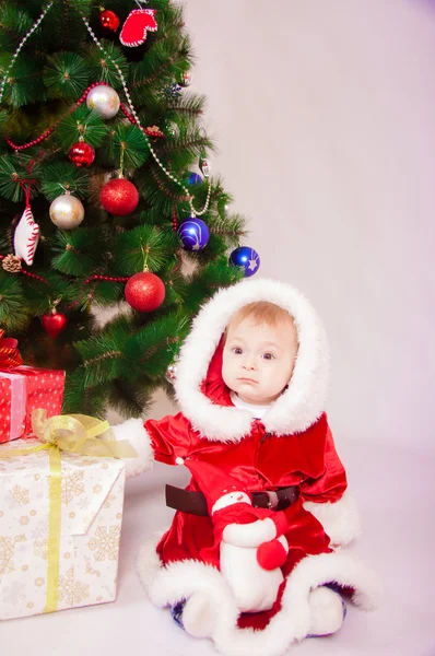 Baby in Santa costume at the Christmas tree — Stock Photo, Image