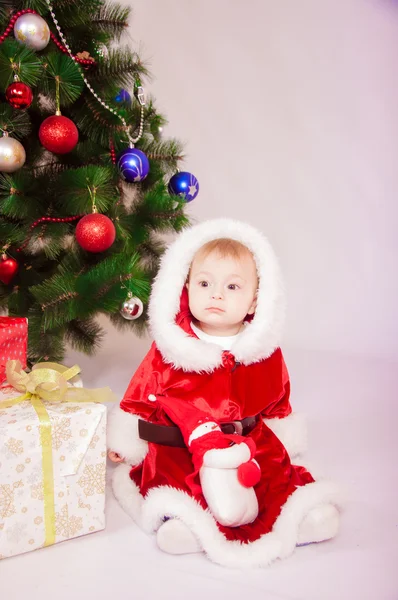 Bebê em traje de Santa na árvore de Natal — Fotografia de Stock