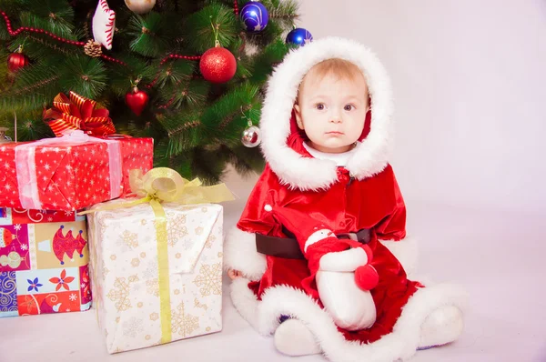 Baby im Weihnachtsmannkostüm am Weihnachtsbaum — Stockfoto