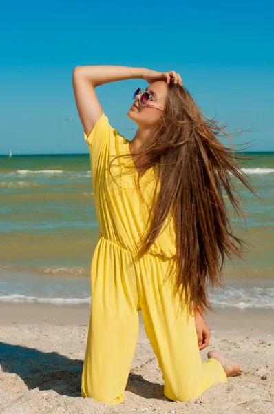 Young beautiful girl with long hair in  sunglasses at the beach — Stock Photo, Image