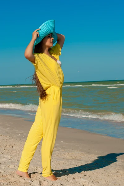 Jovem menina bonita com cabelos longos em chapéu na praia — Fotografia de Stock