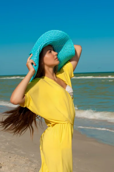 Jovem menina bonita com cabelos longos em chapéu na praia — Fotografia de Stock