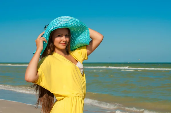 Jovem menina bonita com cabelos longos em chapéu na praia — Fotografia de Stock