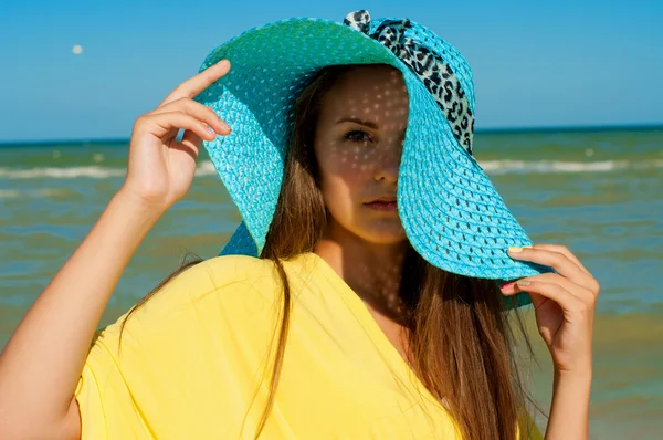 Jovem menina bonita com cabelos longos em chapéu na praia — Fotografia de Stock