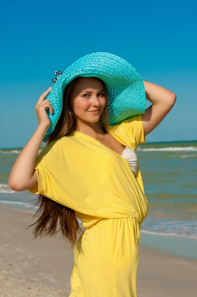 Jovem menina bonita com cabelos longos em chapéu na praia — Fotografia de Stock