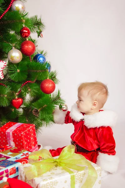 Baby im Weihnachtsmannkostüm am Weihnachtsbaum — Stockfoto