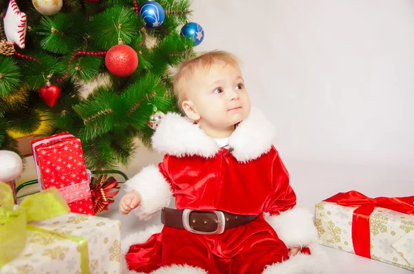 Младенец в костюме Санты у елки — стоковое фото