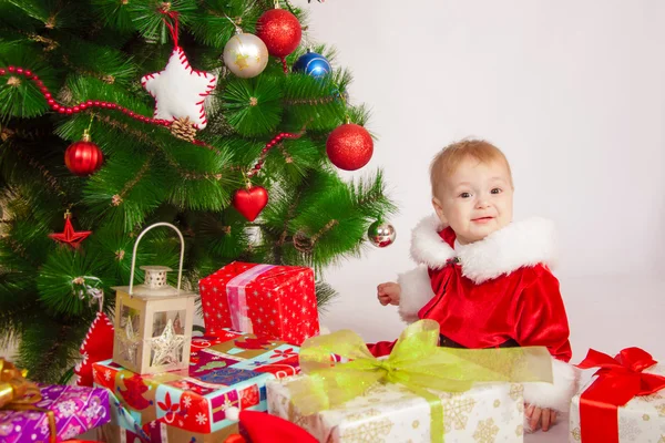 Bebê em traje de Santa na árvore de Natal — Fotografia de Stock