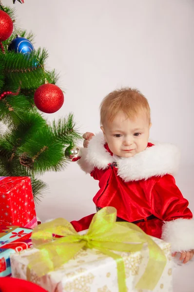 Bebê em traje de Santa na árvore de Natal — Fotografia de Stock