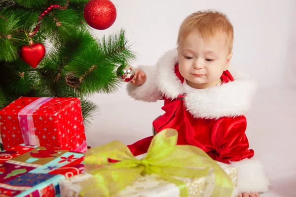 Baby in Santa costume at the Christmas tree — Stock Photo, Image