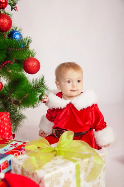 Младенец в костюме Санты у елки — стоковое фото