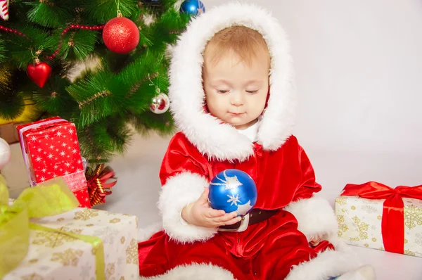 Baby in Santa costume at the Christmas tree — Stock Photo, Image