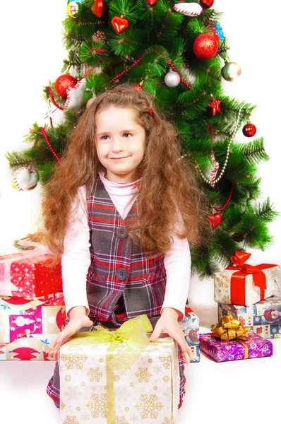 Little girl near the Christmas tree with gifts Stock Photo