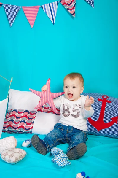 Kleine jongen op een achtergrond van zee decor met een stuk speelgoed — Stockfoto