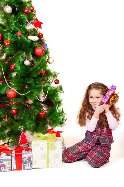 Klein meisje in de buurt van de kerstboom met geschenken — Stockfoto